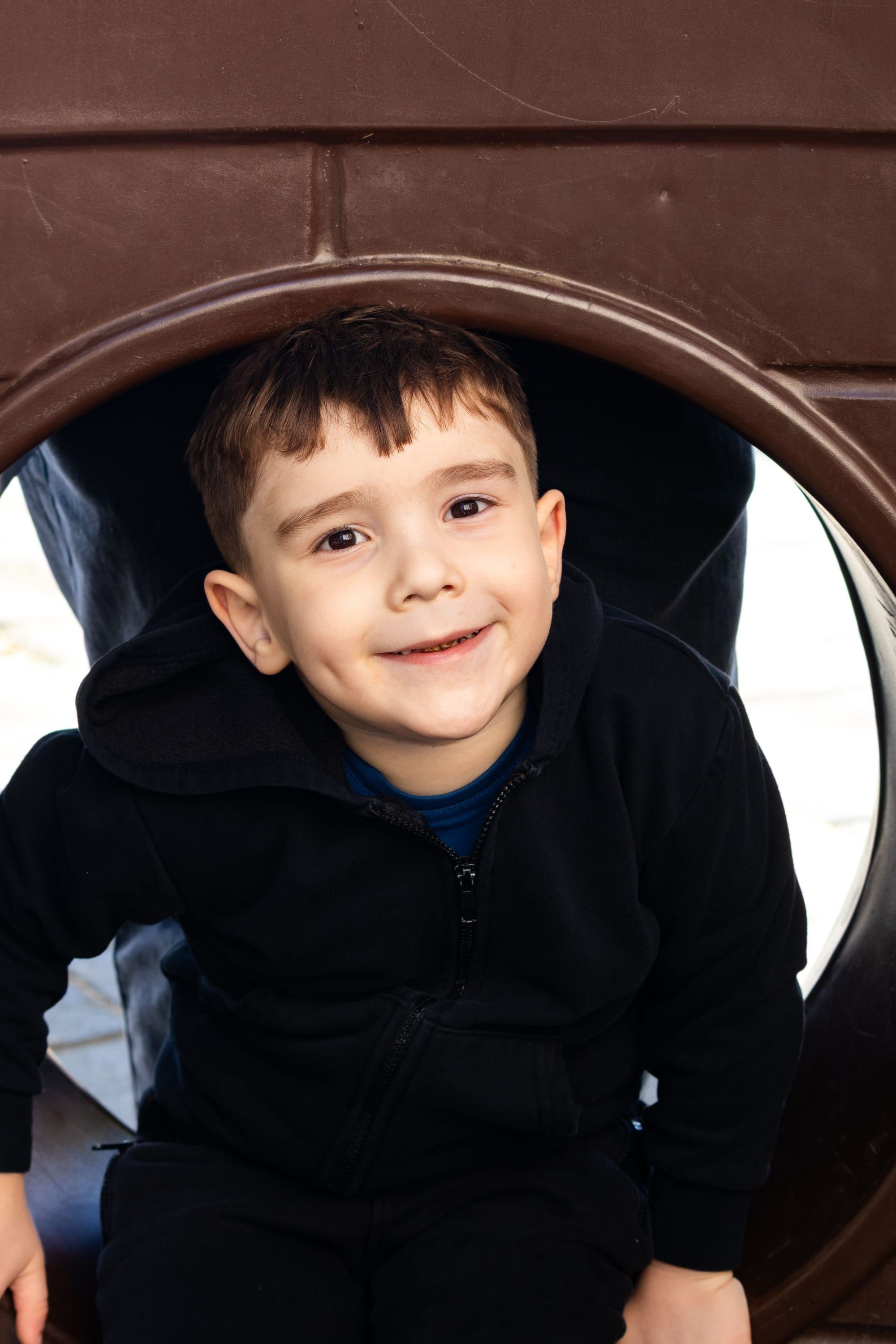 Smiling boy in a play tunnel
