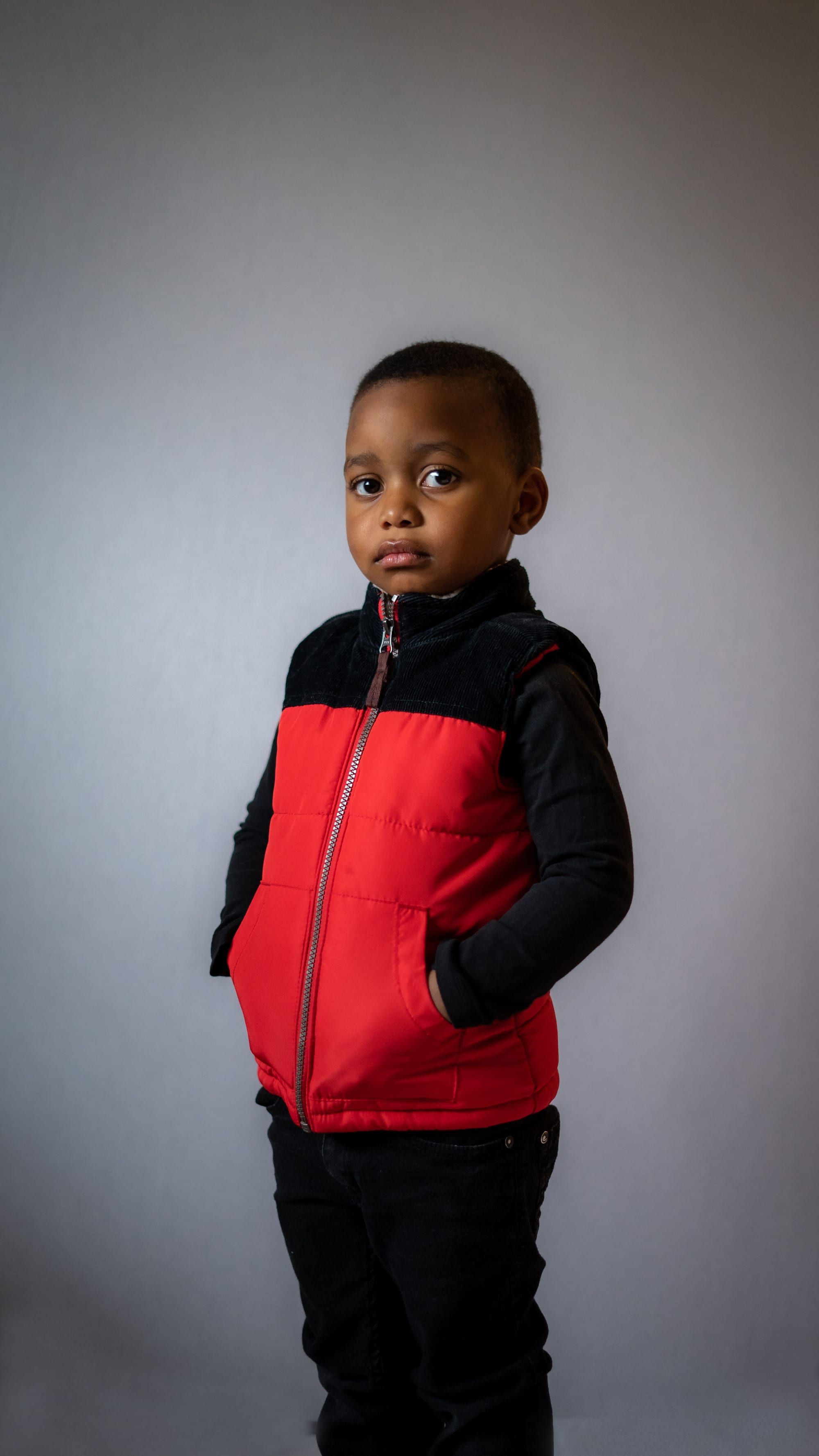 Young boy in a red and black vest